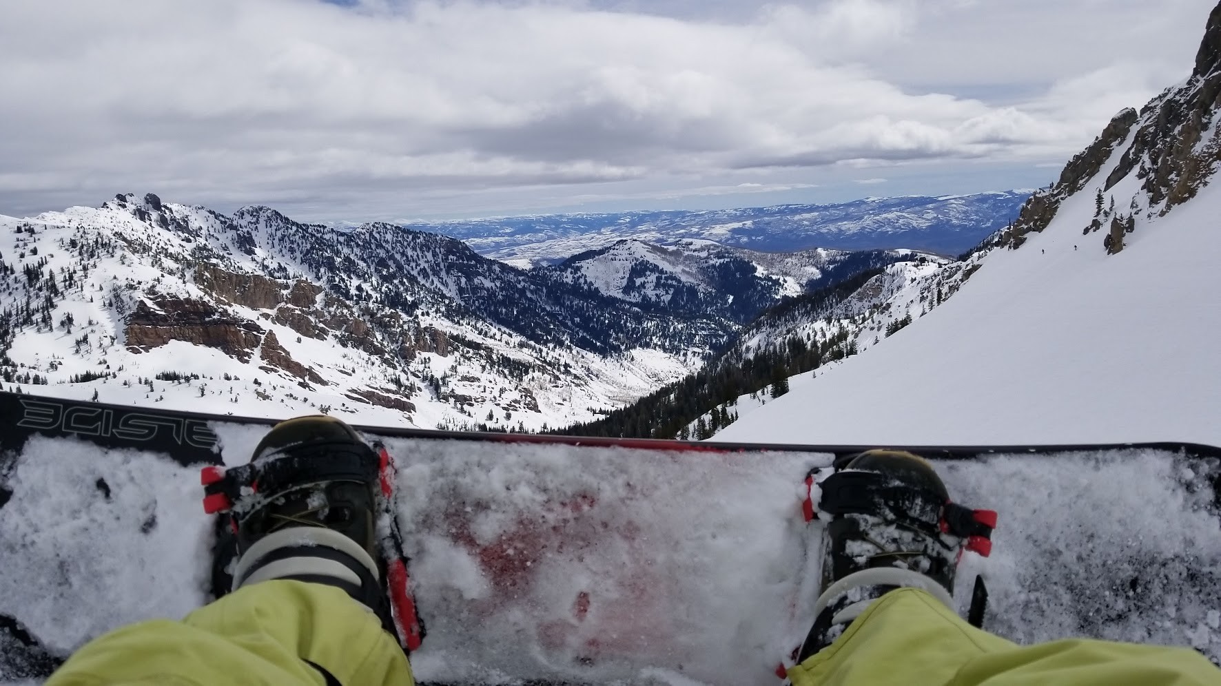 POV from a snowboard looking out at peaks and valleys of the Wasatch Range, Utah.