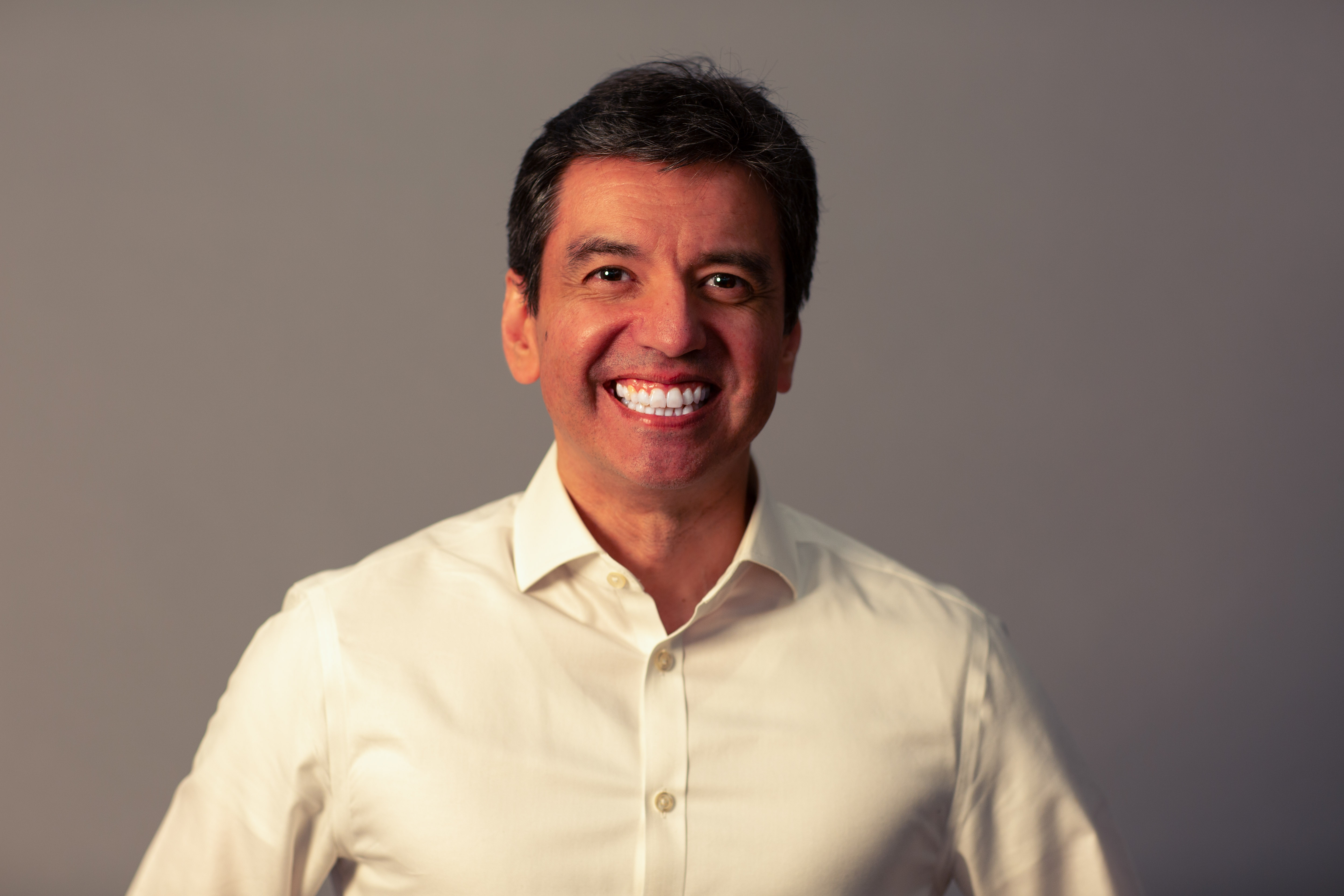 Dennis González, a professional head-and-shoulders portrait.